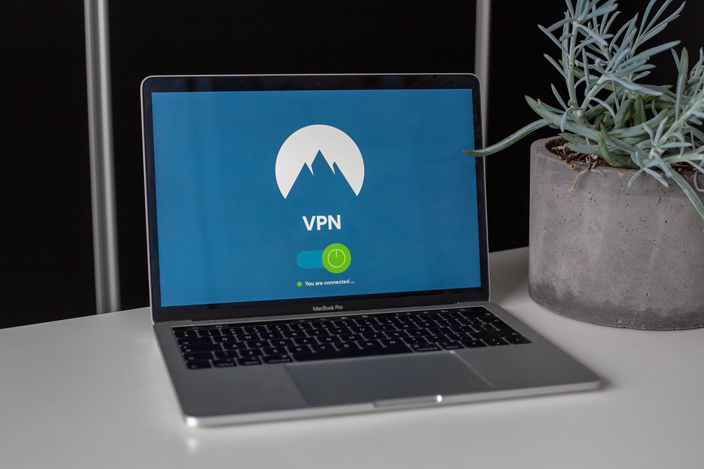 Warning sign over a laptop, symbolizing free VPN account generator scams