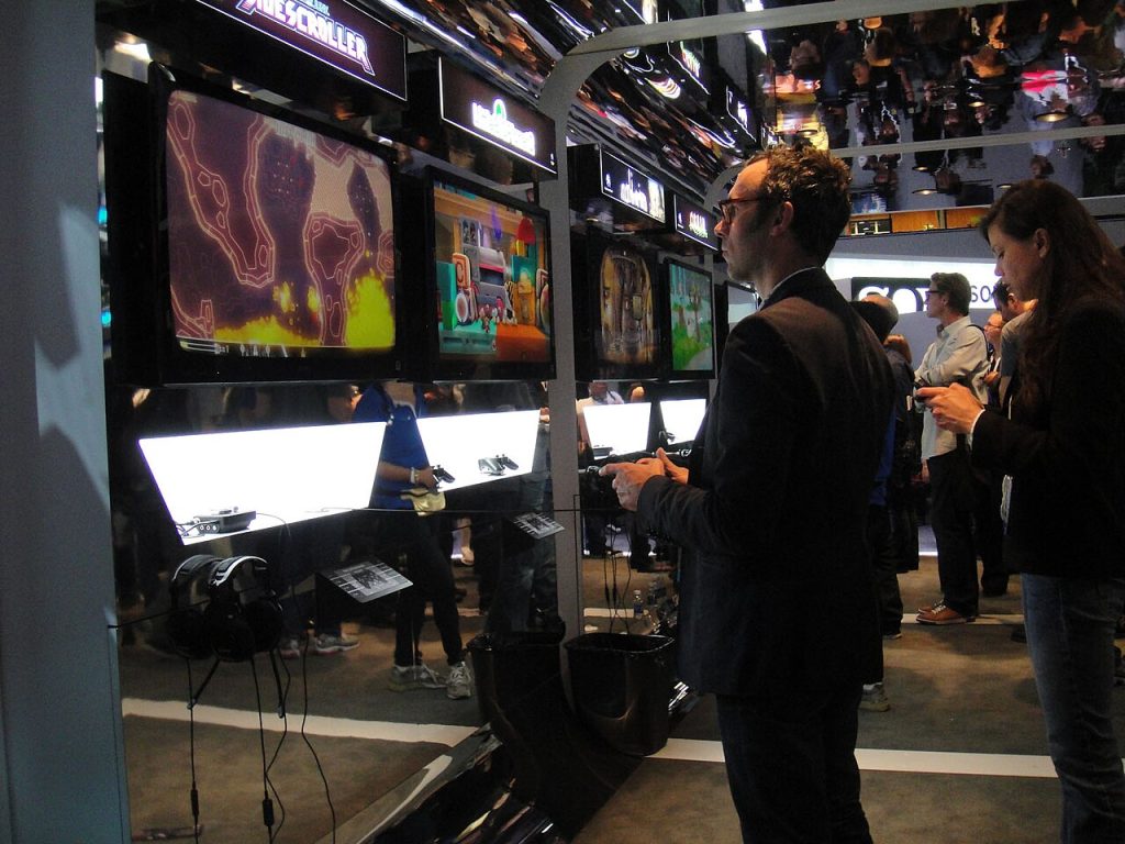 Person searching for free psn codes on a laptop next to a game controller